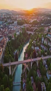 İsviçre 'nin başkenti Bern üzerindeki hava manzarası yukarıdan tarihi bir bölgedir. Bern eski kasabası. Şehir merkezindeki tarihi binalar. Gökyüzü altın günbatımını geniş kuruyor..