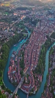 İsviçre 'nin başkenti Bern üzerindeki hava manzarası yukarıdan tarihi bir bölgedir. Bern eski kasabası. Şehir merkezindeki tarihi binalar. Gökyüzü altın günbatımını geniş kuruyor..