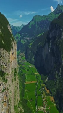 İnsansız hava aracı, arkasında dağlar olan yeşil renkli vadilerin üzerinden uçuyor. Yüksek Dağlar İsviçre 'nin ünlü simgeleridir. İsviçre 'deki Idyllic dağ manzarası, İsviçre kırsal havası.