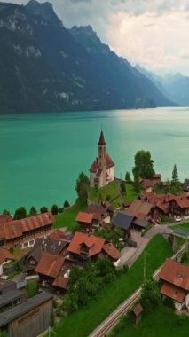 Alpler arasındaki gölün kıyısındaki geleneksel İsviçre evlerinin insansız hava aracı görüntüsü. Brienz, İsviçre. İsviçre 'nin Brienz şehrinin insansız hava aracı görüntüleri. Yazın İsviçre 'yi gezmek.