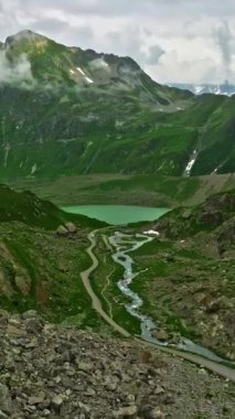 Dağlarda kalp şeklinde göl. İnsansız hava aracı güzel göl üzerinde uçuyor. Dağ tepeleri ve göl. İsviçre yaz turizmi merkezi. Dağların ve gölün inanılmaz manzarası.