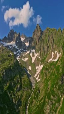İnsansız hava aracı, arkasında dağlar olan yeşil renkli vadilerin üzerinden uçuyor. Yüksek Dağlar İsviçre 'nin ünlü simgeleridir. İsviçre 'deki Idyllic dağ manzarası, İsviçre kırsal havası.