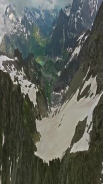 Yüksek dağların arasındaki kadim kar buzulu. Dağların zirveleri karla kaplıdır. İsviçre Alpleri 'nin dağlık arazisi. Drone dağdaki erimiş buzullara doğru yavaşça uçuyor..