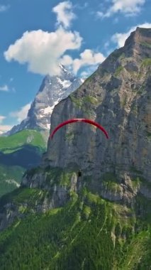 Paraglider 'ın İsviçre' deki dağlık dağlarda üzerinde İsviçre bayrağı olan hava manzarası..