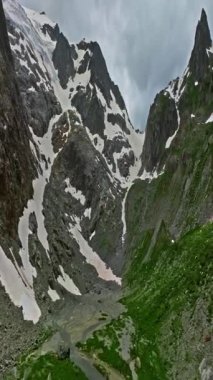 İnsansız hava aracı, arkasında dağlar olan yeşil renkli vadilerin üzerinden uçuyor. Yüksek Dağlar İsviçre 'nin ünlü simgeleridir. İsviçre 'deki Idyllic dağ manzarası, İsviçre kırsal havası.