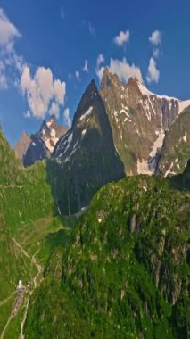 İnsansız hava aracı, arkasında dağlar olan yeşil renkli vadilerin üzerinden uçuyor. Yüksek Dağlar İsviçre 'nin ünlü simgeleridir. İsviçre 'deki Idyllic dağ manzarası, İsviçre kırsal havası.