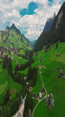 İnsansız hava aracı, arkasında dağlar olan yeşil renkli vadilerin üzerinden uçuyor. Yüksek Dağlar İsviçre 'nin ünlü simgeleridir. İsviçre 'deki Idyllic dağ manzarası, İsviçre kırsal havası.