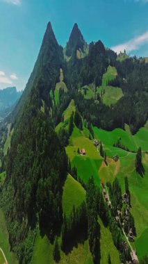 İnsansız hava aracı, arkasında dağlar olan yeşil renkli vadilerin üzerinden uçuyor. Yüksek Dağlar İsviçre 'nin ünlü simgeleridir. İsviçre 'deki Idyllic dağ manzarası, İsviçre kırsal havası.