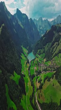 İnsansız hava aracı, arkasında dağlar olan yeşil renkli vadilerin üzerinden uçuyor. Yüksek Dağlar İsviçre 'nin ünlü simgeleridir. İsviçre 'deki Idyllic dağ manzarası, İsviçre kırsal havası.