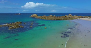 Plage des Amiets 'teki berrak turkuaz su ve dalgalarla sakin sahilin havadan görüntüsü..