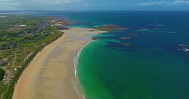 Plage des Amiets 'teki berrak turkuaz su ve dalgalarla sakin sahilin havadan görüntüsü..