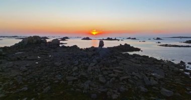 Gün batımında Fransa 'daki Atlantik Okyanusu' nun inanılmaz kayalık kıyılarının havadan görüntüsü. Bretagne 'ın fotoğrafını çekiyorum. Kuzey Brittany 'de kayaların üzerinden uçan ve onlara çarpan bir dron..