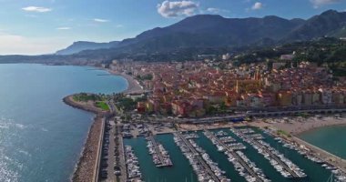 Menton, Fransa 'nın havadan görünüşü. Yazın renkli Menton kasabası, tarihi binalar ve gün batımında güzel plajlar. Tarihi kilisenin ve renkli çatıların hava görüntüleri..