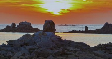 Gün batımında Fransa 'daki Atlantik Okyanusu' nun inanılmaz kayalık kıyılarının havadan görüntüsü. Bretagne 'ın fotoğrafını çekiyorum. Kuzey Brittany 'de kayaların üzerinden uçan ve onlara çarpan bir dron..