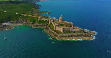La Latte Kalesi 'nin havadan görünüşü, Cap Frehel, Brittany, Fransa' daki Chateau de la Roche Guyon kumtaşı kayalıklarında dalgaların ezdiği güneşli bir yaz gününde.