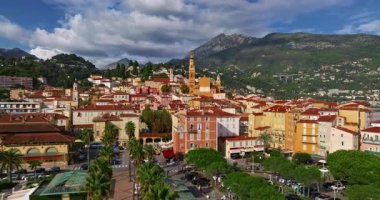 Menton, Fransa 'nın havadan görünüşü. Yazın renkli Menton kasabası, tarihi binalar ve gün batımında güzel plajlar. Tarihi kilisenin ve renkli çatıların hava görüntüleri..