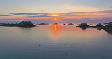 Gün batımında Fransa 'daki Atlantik Okyanusu' nun inanılmaz kayalık kıyılarının havadan görüntüsü. Bretagne 'ın fotoğrafını çekiyorum. Kuzey Brittany 'de kayaların üzerinden uçan ve onlara çarpan bir dron..
