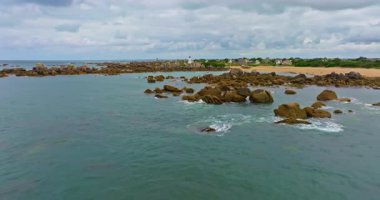 Gün batımında Fransa 'daki Atlantik Okyanusu' nun inanılmaz kayalık kıyılarının havadan görüntüsü. Bretagne 'ın fotoğrafını çekiyorum. Kuzey Brittany 'de kayaların üzerinden uçan ve onlara çarpan bir dron..