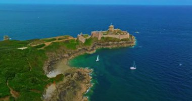 La Latte Kalesi 'nin havadan görünüşü, Cap Frehel, Brittany, Fransa' daki Chateau de la Roche Guyon kumtaşı kayalıklarında dalgaların ezdiği güneşli bir yaz gününde.