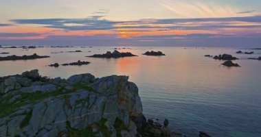 Gün batımında Fransa 'daki Atlantik Okyanusu' nun inanılmaz kayalık kıyılarının havadan görüntüsü. Bretagne 'ın fotoğrafını çekiyorum. Kuzey Brittany 'de kayaların üzerinden uçan ve onlara çarpan bir dron..