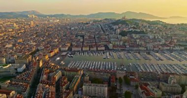 Birçok tekne ve yat şehir limanına park edilmiştir. Sabah güneşinde Marsilya limanının havadan görüntüsü. Fransa 'nın güneyindeki Marsilya' nın insansız hava aracı görüntüsü.