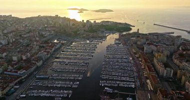 Birçok tekne ve yat şehir limanına park edilmiştir. Sabah güneşinde Marsilya limanının havadan görüntüsü. Fransa 'nın güneyindeki Marsilya' nın insansız hava aracı görüntüsü.