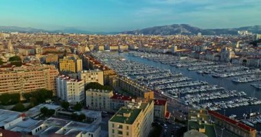 Birçok tekne ve yat şehir limanına park edilmiştir. Sabah güneşinde Marsilya limanının havadan görüntüsü. Fransa 'nın güneyindeki Marsilya' nın insansız hava aracı görüntüsü.