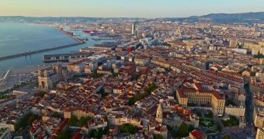 Sabah güneşinde Marsilya şehrinin havadan görünüşü. Fransız şehrinin çatıları. Bir sürü insan kıyı kasabasında geziniyor. Fransa 'nın güneyindeki Marsilya' nın insansız hava aracı görüntüsü.