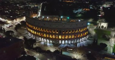 Geceleri Colosseum 'un uçan insansız hava aracını kuruyorum. Kolezyum mimari aydınlatmayla aydınlatıldı. Roma şehir merkezi, İtalya. Kolezyum ve Roma 'daki İmparatorluk Forumları.
