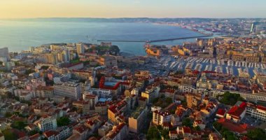 Sabah güneşinde Marsilya şehrinin havadan görünüşü. Fransız şehrinin çatıları. Bir sürü insan kıyı kasabasında geziniyor. Fransa 'nın güneyindeki Marsilya' nın insansız hava aracı görüntüsü.