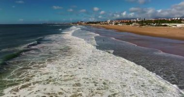 Arka planda ünlü bir köprü olan Portekiz 'deki bir kalenin insansız hava aracı görüntüsü. Portekiz, Carcavelos sahilinden deniz feneri kulesi olan Aziz Julian Kalesi. Carcavelos 'taki Atlantik okyanus dalgaları plajı.