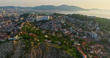 Sabah güneşinde Marsilya şehrinin havadan görünüşü. Fransız şehrinin çatıları. Bir sürü insan kıyı kasabasında geziniyor. Fransa 'nın güneyindeki Marsilya' nın insansız hava aracı görüntüsü.