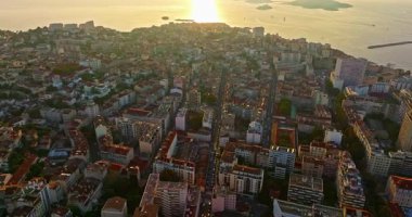 Sabah güneşinde Marsilya şehrinin havadan görünüşü. Fransız şehrinin çatıları. Bir sürü insan kıyı kasabasında geziniyor. Fransa 'nın güneyindeki Marsilya' nın insansız hava aracı görüntüsü.
