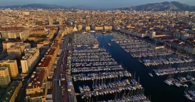 Birçok tekne ve yat şehir limanına park edilmiştir. Sabah güneşinde Marsilya limanının havadan görüntüsü. Fransa 'nın güneyindeki Marsilya' nın insansız hava aracı görüntüsü.