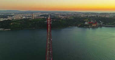 Portekiz, Lizbon 'da gün batımında Tagus Nehri üzerindeki 25 de Abril köprüsünün hava görüntüsü.