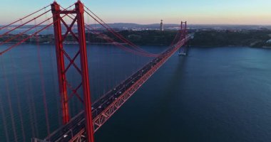 Portekiz, Lizbon 'da gün batımında Tagus Nehri üzerindeki 25 de Abril köprüsünün hava görüntüsü.