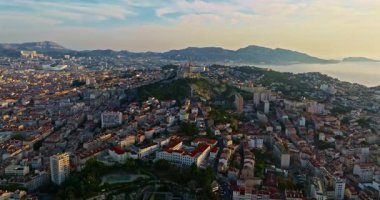Sabah güneşinde Marsilya şehrinin havadan görünüşü. Fransız şehrinin çatıları. Bir sürü insan kıyı kasabasında geziniyor. Fransa 'nın güneyindeki Marsilya' nın insansız hava aracı görüntüsü.