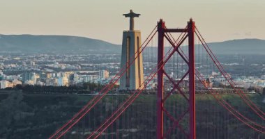 Portekiz, Lizbon 'da gün batımında Tagus Nehri üzerindeki 25 de Abril köprüsünün hava görüntüsü.