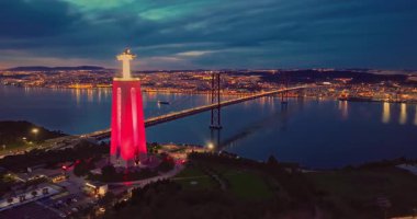 Lizbon 'daki Kral İsa' nın günbatımında Lizbon, Portekiz 'de katolik anıtı üzerindeki hava görüşü. Gece ya da akşam Sığınak 'ın kırmızı arka planı ve güzel bir akşam manzarası.