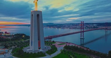 Lizbon 'daki Kral İsa' nın günbatımında Lizbon, Portekiz 'de katolik anıtı üzerindeki hava görüşü. Gece ya da akşam Sığınak 'ın kırmızı arka planı ve güzel bir akşam manzarası.