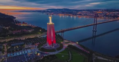 Lizbon 'daki Kral İsa' nın günbatımında Lizbon, Portekiz 'de katolik anıtı üzerindeki hava görüşü. Gece ya da akşam Sığınak 'ın kırmızı arka planı ve güzel bir akşam manzarası.