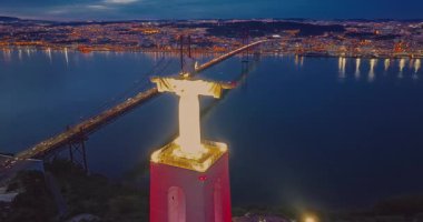 Lizbon 'daki Kral İsa' nın günbatımında Lizbon, Portekiz 'de katolik anıtı üzerindeki hava görüşü. Gece ya da akşam Sığınak 'ın kırmızı arka planı ve güzel bir akşam manzarası.