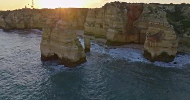 Günbatımında Ponta da Piedade, Lagos, Portekiz 'deki dramatik uçurumların ve deniz fenerinin havadan görünüşü.