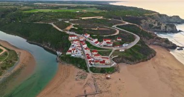 Yel değirmeni ve pitoresk çatıları olan küçük köyün havadan görünüşü, Aldatmaca, Portekiz.