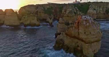 Günbatımında Ponta da Piedade, Lagos, Portekiz 'deki dramatik uçurumların ve deniz fenerinin havadan görünüşü.