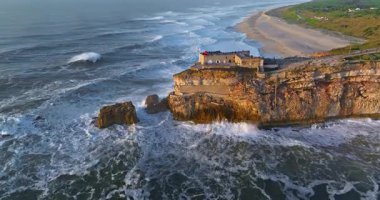 Nazare Deniz fenerinin hava manzarası. Dünyanın en büyük dalgaları çarpıcı deniz fenerinin kayalarına çarpıyor. Portekiz.