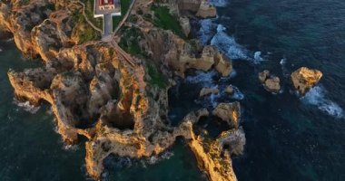 Ponta da Piedade deniz fenerinin Lagos, Portekiz 'deki kayalıklar, botlar ve turkuaz sularla çevrili hava manzarası..