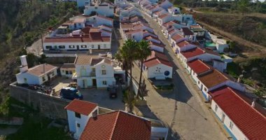 Yel değirmeni ve pitoresk çatıları olan küçük köyün havadan görünüşü, Aldatmaca, Portekiz.
