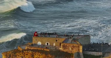 Nazare Deniz fenerinin hava manzarası. Dünyanın en büyük dalgaları çarpıcı deniz fenerinin kayalarına çarpıyor. Portekiz.