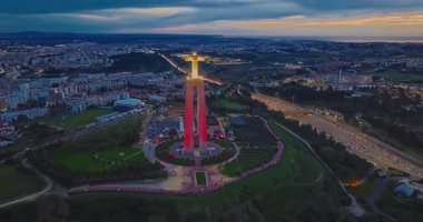 Lizbon 'daki Kral İsa' nın günbatımında Lizbon, Portekiz 'de katolik anıtı üzerindeki hava görüşü. Gece ya da akşam Sığınak 'ın kırmızı arka planı ve güzel bir akşam manzarası.